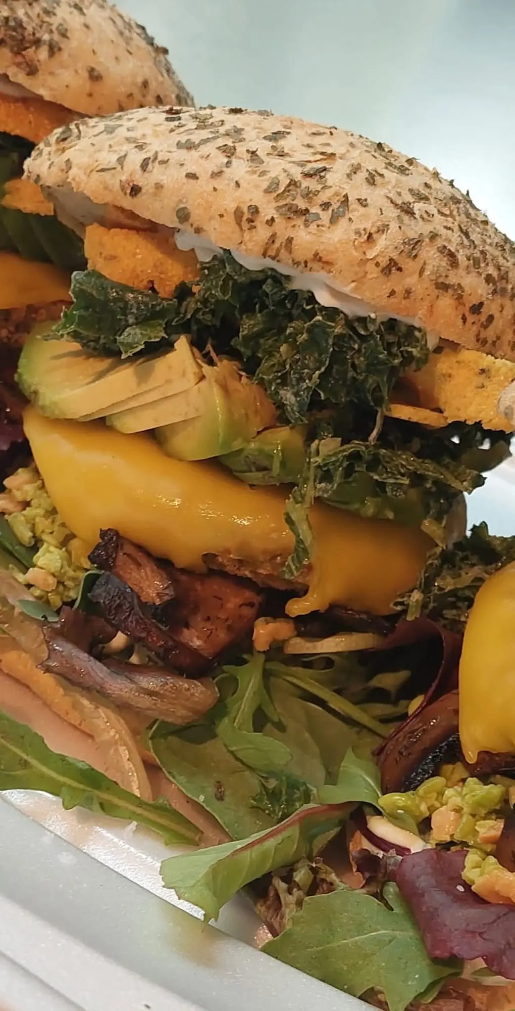 Plant-based burger with avocado, greens and melted vegan cheese