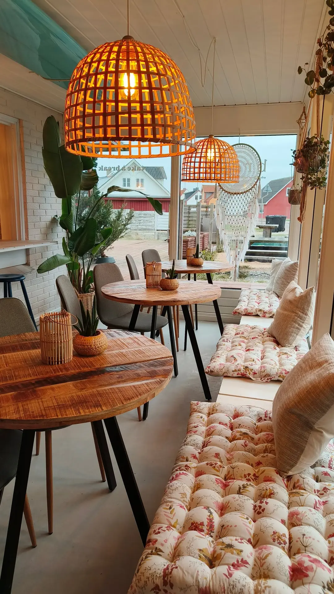 Inside The Break Café with wicker lamps, plants and cosy seating
